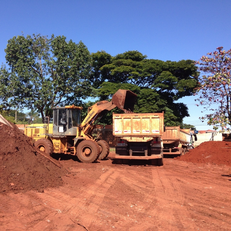 A bulldozer loading dirt into a dump truck on a construction site. This is typical of earthworks projects in Tacoma South to prepare the ground for new buildings or infrastructure.